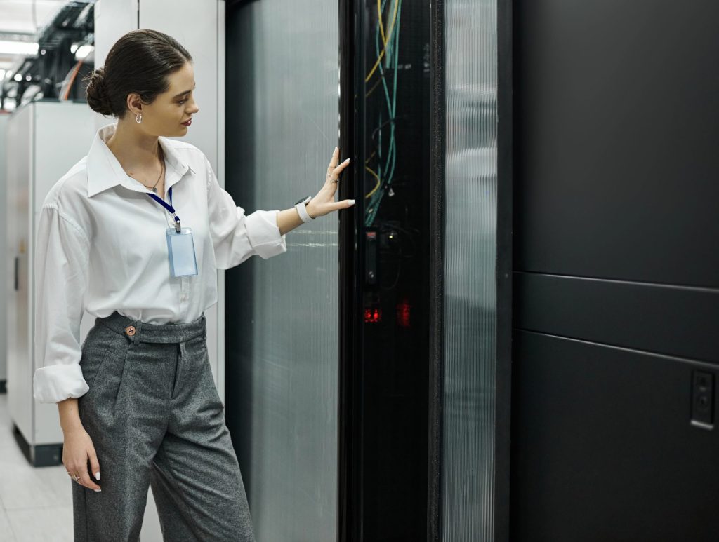 A skilled IT specialist works with computer systems in a contemporary server room.