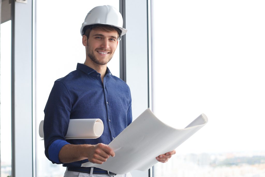 Shot of male architect wearing hardhat and inspecting new building.