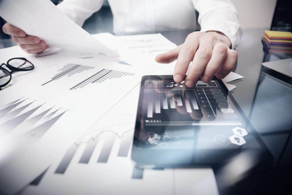 Risk Management Work process.Photo Trader working Market Report Documents Touching Screen Tablet.Using Graphic Icons,Stock Exchanges Reports. Business Project Startup. Horizontal,